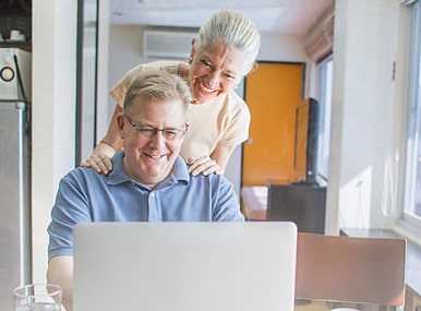 man and woman looking at computer smiling