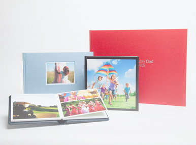 an array of photo books, some open and some closed, showing their covers and contents